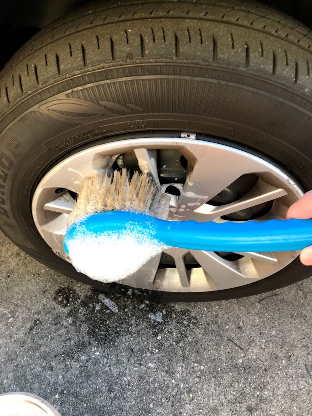 フォームガンでミラーやタイヤ周りなど洗車機のブラシが届かない場所を予洗いしている様子