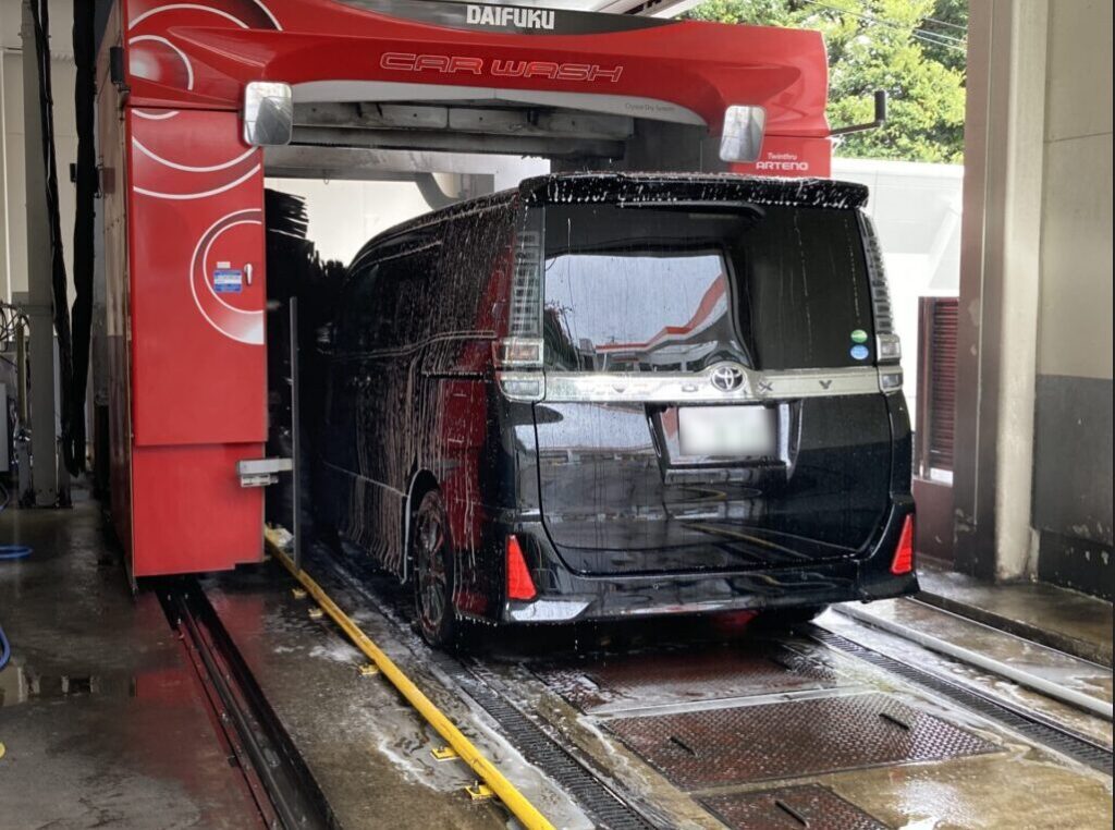 洗車機の高圧ジェットで車の花粉を洗い流している様子